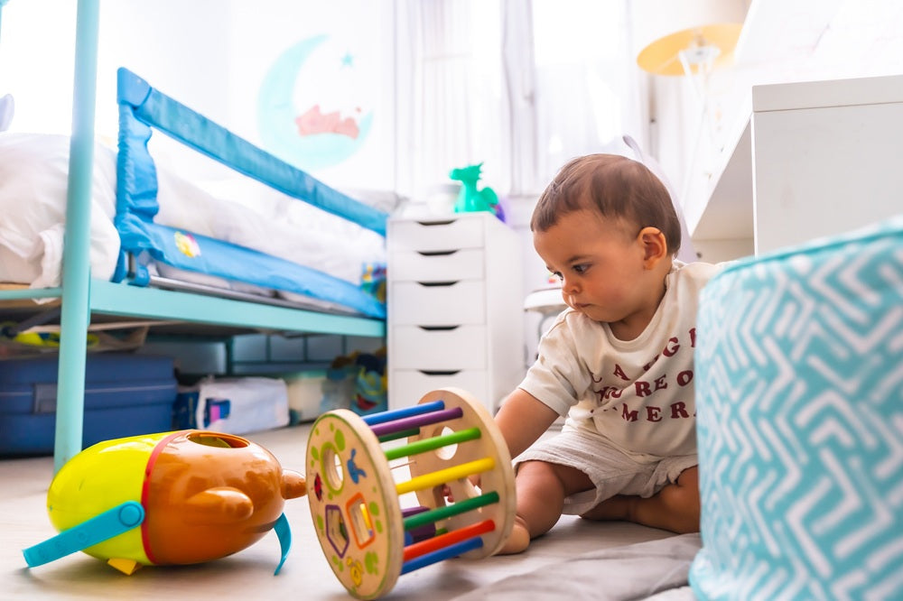 Baby spielt im Kinderzimmer auf dem Boden