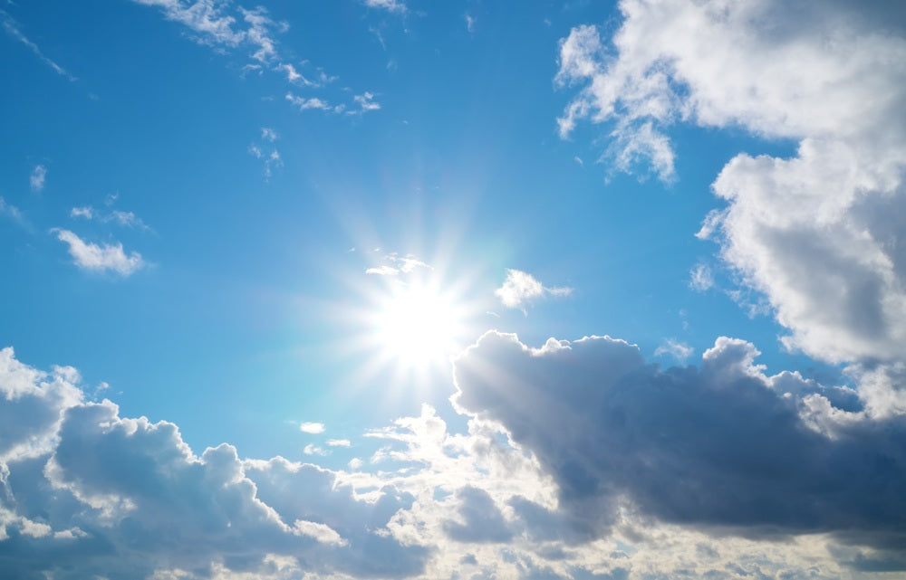 Blauer himmel, mit Wolken un der Sonne