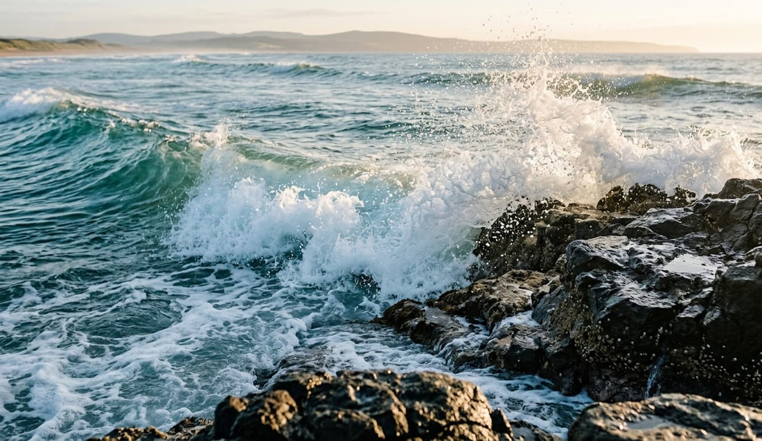 Brechende Wellen an einer Küste, feine Gischt steht in der Luft