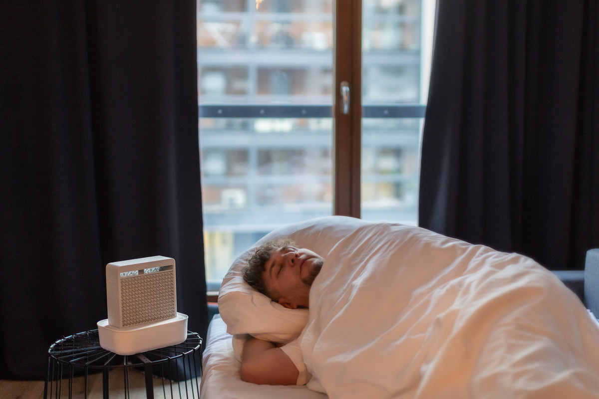 Man sleeping in bed with SalinoVatis Aura in Chalk on a bedside table